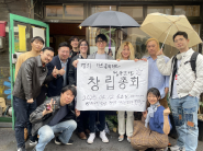 경기아트콜렉티브 협동조합 창립 이사회 멤버들이 창립총회 장소인 딱따구리 책방 앞에서 창립 내용을 알리는 현수막을 들고 기념 사진 촬영에 임하고 있다.