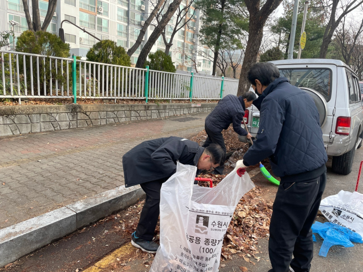 모아진 낙엽을 화서동에서 지원한 봉투에 담고 있다.