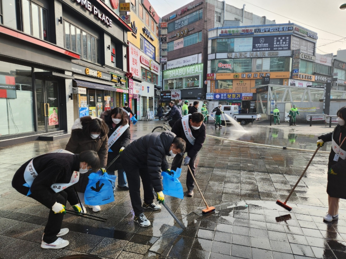 직원 및 주민들이 수원역 광장에서 대대적인 정화활동을 펼치고 있다