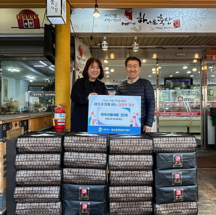 못골시장 하나로축산 대표와 매교동 맞춤형복지팀장이 후원물품 앞에서 기념촬영을 하고 있다