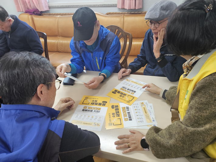 매탄1동지역사회보장협의체 위원들이 어르신들에게 수원새빛돌봄(누구나) 사업에 대해 설명하고 있다.