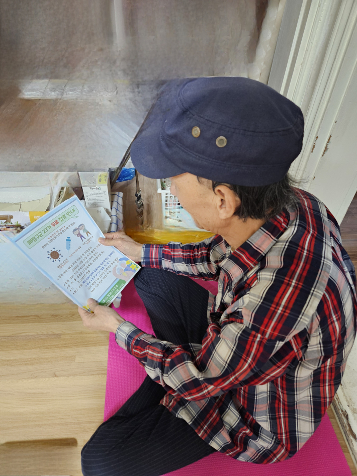 홀몸어르신이 방문간호사가 전달한 폐렴구균 예방접종 안내문을 보고있다. 