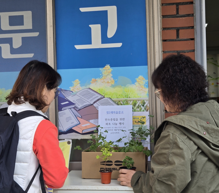 정2새마을문고회원들이 식목일을 맞이하여 새싹화분을 나누고있다.  