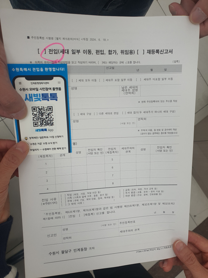 전입신고 민원인에게 새빛톡톡 안내사항을 포함한 환영카드를 건네고 있다.