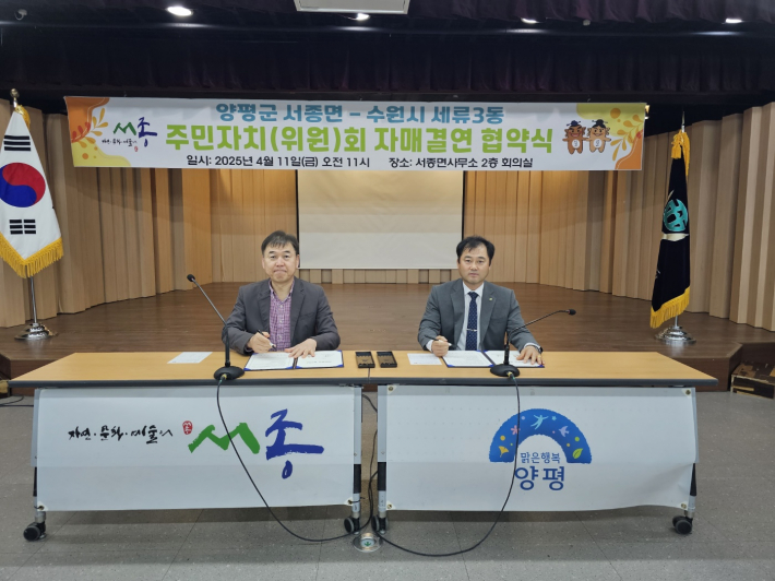세류3동 주민자치회장과 서종면 주민자치위원회 위원장이 협약서에 서명하고 있다. 