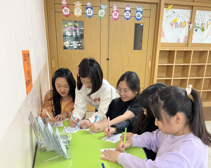 사회복지실에서 할 수 있는 활동을 정답지에 쓰고 있는 학생들 모습