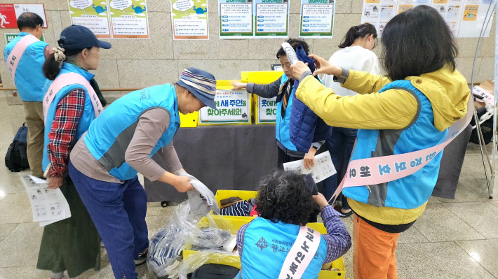 수거해 온 의류를 살피며 기뻐하는 사람들