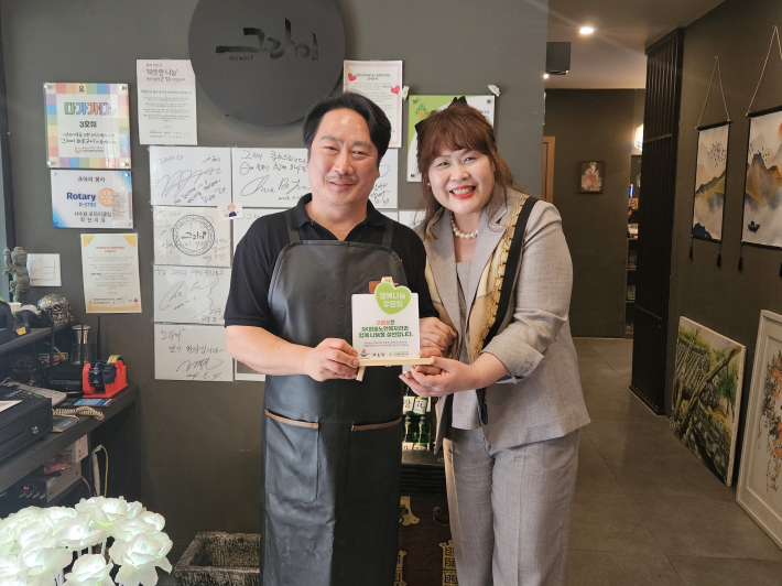 구운정 식당에서 SK청솔노인복지관 행복나눔 후원회 나눔현판을 전달하고 있다.