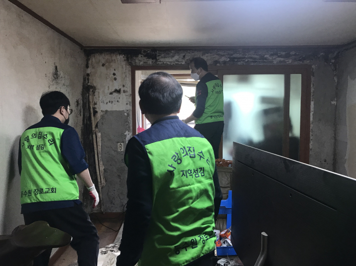동수원장로교회 '사랑의집수리' 봉사자들이 주거환경 개선을 위해 벽지를 뜯어 내고 있다.