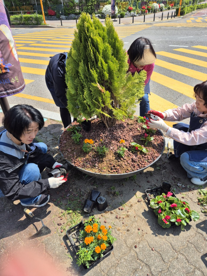 화서2동 꽃뫼환경대전환단이 초화식재 등 화서2동 환경정비를 위해 활동하고 있다.