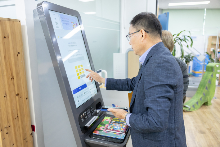 영통종합사회복지관 이필신 관장이 반달어린이도서관 내 RFID시스템을 이용하는 모습이다.
