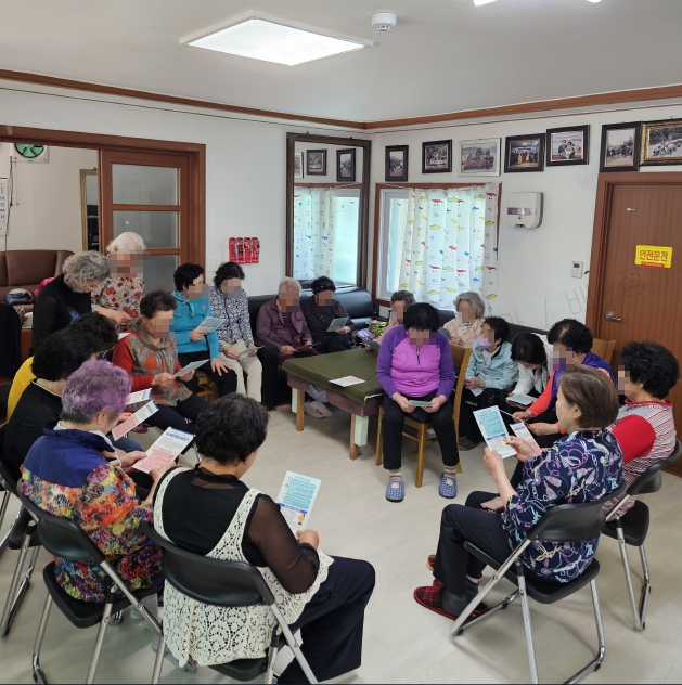 경로당 어르신들이 심뇌혈관질환 바로알기 교육 자료를 보고 있다.