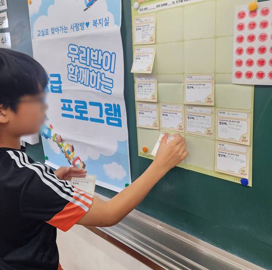 한 학생이 활동판에 작성한 '응원의 말과 도움행동' 활동지를 붙이고 있다.