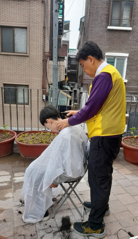 송용주 지역사회보장협의체 위원이 장애인을 위한 미용봉사에 임하고 있다.