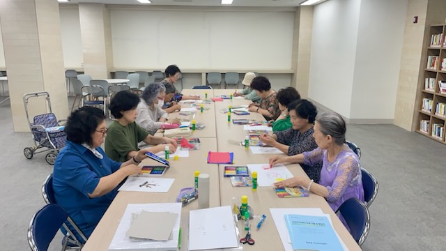 미술치료 수업에서 어르신들이 집중해 작품을 제작하는 모습  