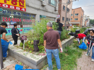 김미현 곡선동장님, 임영환 회장님, 마을만들기협의회 회원들이 함께 손바닥 정원을 정비하고 있는 모습.