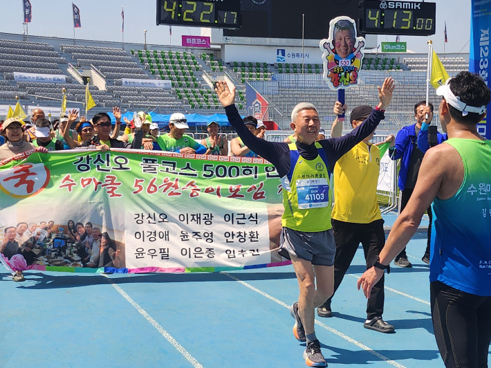 마라톤 풀코스 500회 골인 후 축하 환호를 받는 강신오 참가자