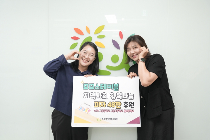 능실종합사회복지관 부장과 모모스테이블 대표가 후원 기념 판넬을 들고 사진을 찍고 있다.