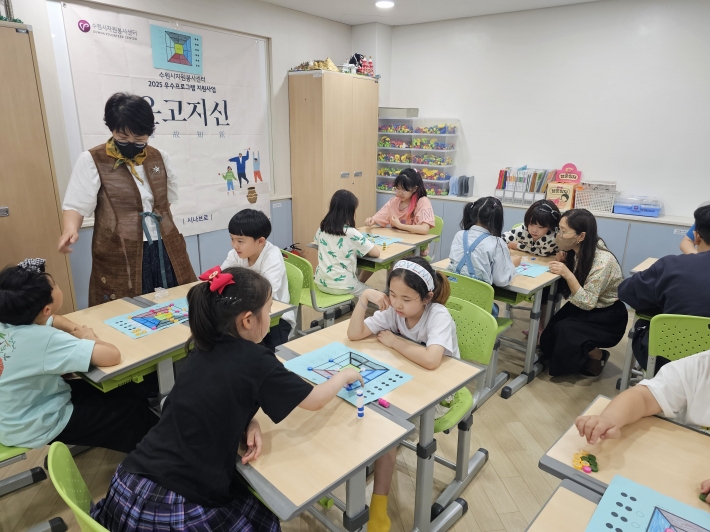 수원시다함께돌봄센터11호점의 아동들이 '시나브로'단체의 온고지신 프로그램(참고누놀이)에 참여하고 있다.