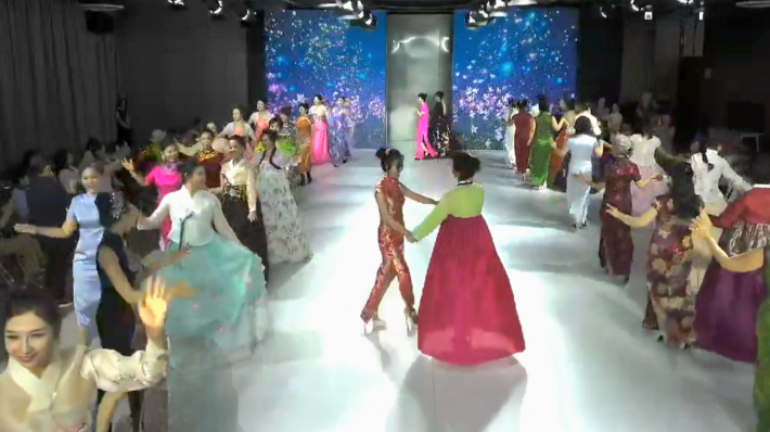 경기수원시니어모델협회 심미경 회장이 치파오를 입고 한복을 입은 칭다오모델과 골라보쇼를 하고 있다.