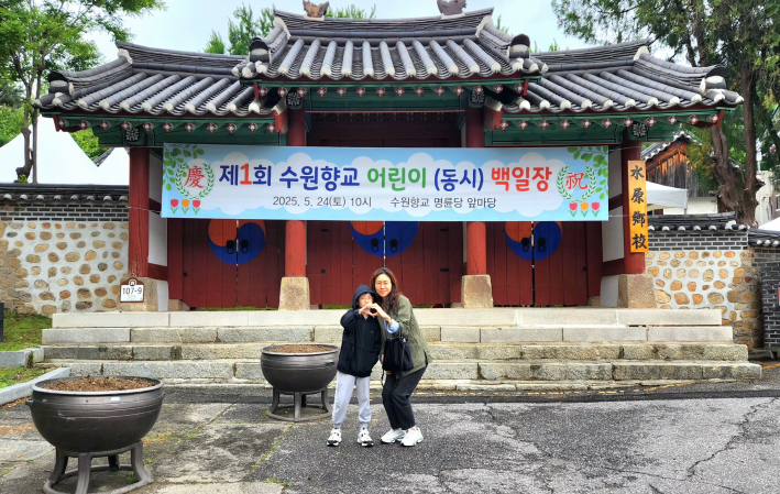 행사장에 가기 전 매교초 4학년 김승호 군과 학부형이 하트를 날리며 사진촬영에 응했다.