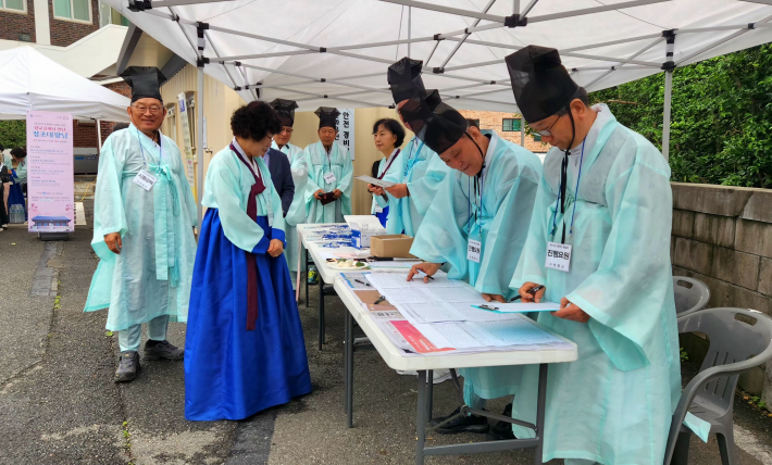 수원향교 진행요원들이 백일장 참가자들에게 접수대에서 등로부, 신분확인, 서명을 받고 있다.