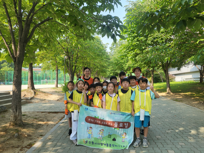 수원시다함께돌봄센터11호점의 아동들이 화서동 숙지공원에서 플로킹활동에 참여하고 있다.