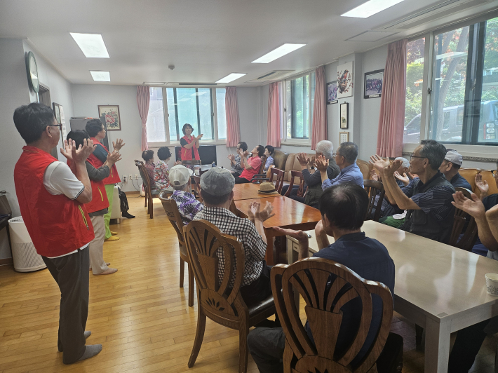 변민자 매탄1동지역사회보장협의체 위원장이 어르신들에게 건강박수를 알려드리고 있다