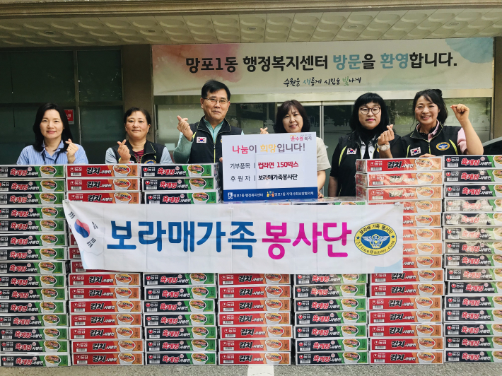 보라매가족봉사단에서 망포1동으로 라면을 기탁하며 기념촬영을 하고 있다