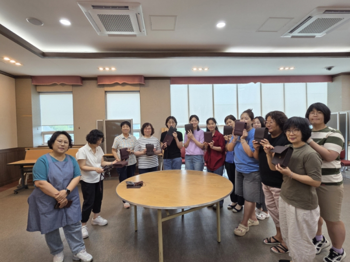 지역주민들이 손수 크로스백을 들고 단체사진 촬영을 하였다