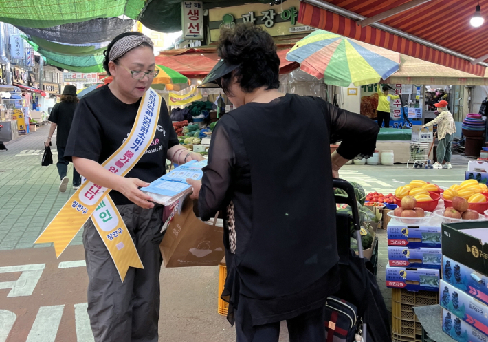 물가모니터요원이 시민에게 행사 내용을 안내하고 있다.