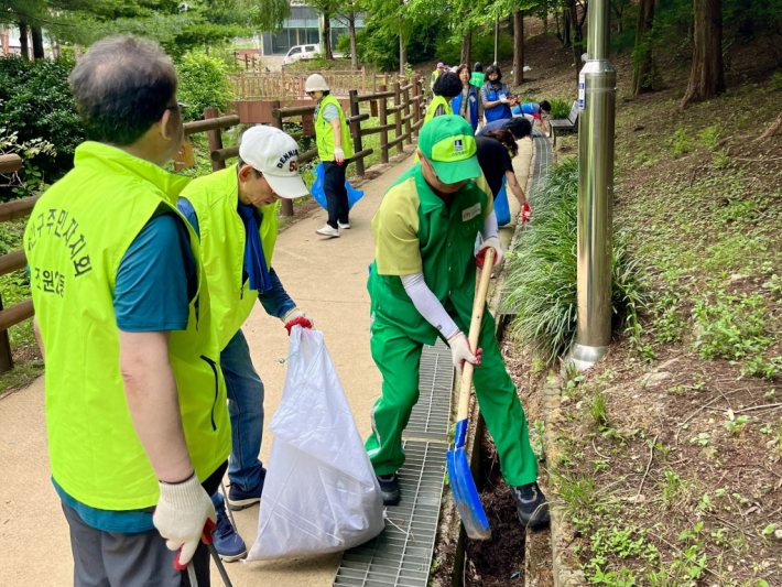 장마에 대비하여 조원천 산책길 부근 배수로를 점검·정비하는 모습