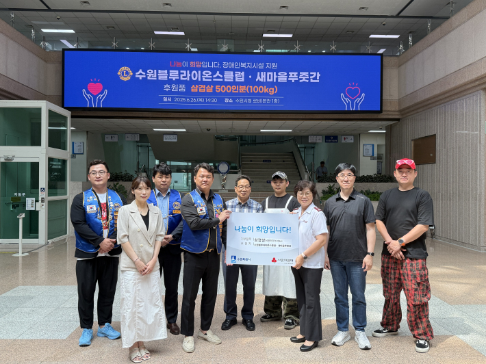 수원블루라이온스클럽·새마을푸줏간, 수원시 장애인복지시설 관계자가 전자현수막 앞에서 사진을 찍고 있다. 