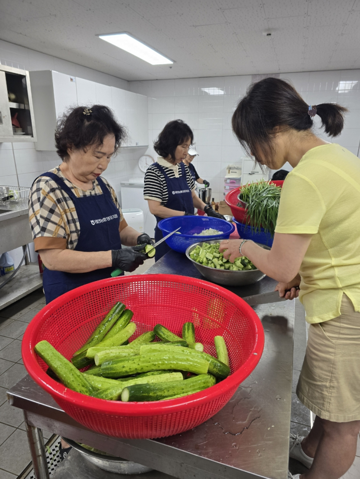 지역사회보장협의체 위원들이 정성스럽게 반찬을 준비하고 있다.