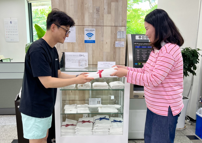 올해 조원2동에서 50번째 출생신고를 한 부모에게 손수 만든 아기용품을 전달하는 모습