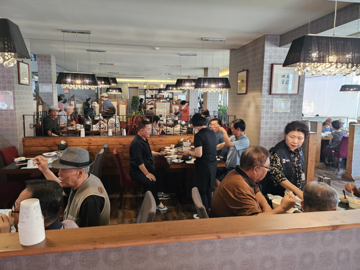 2025년 매탄1동 어르신 청춘잔치에 참석한 어르신들이 맛있게 식사를 하고 있다