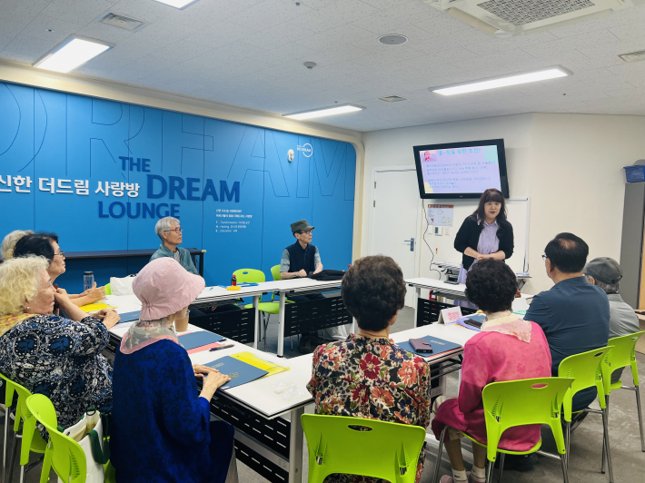 SK청솔노인복지관 김용옥 관장이 참여 어르신들께 '꿀잠노력상'을 전달하며 응원하고 있다.