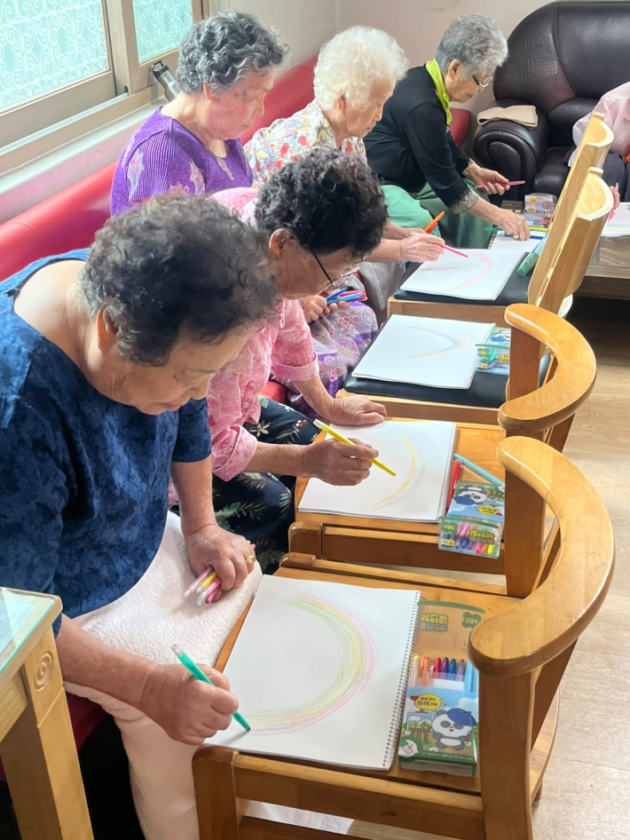 매탄1동 치매예방 미술치료 프로그램에 참여한 어르신들이 자신만의 무지개를 그리고 있다