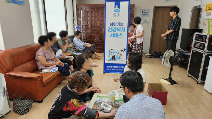 권선2동 행정복지센터 직원이 경로당에서 어르신들 혈압 및 혈당을 측정하는 모습