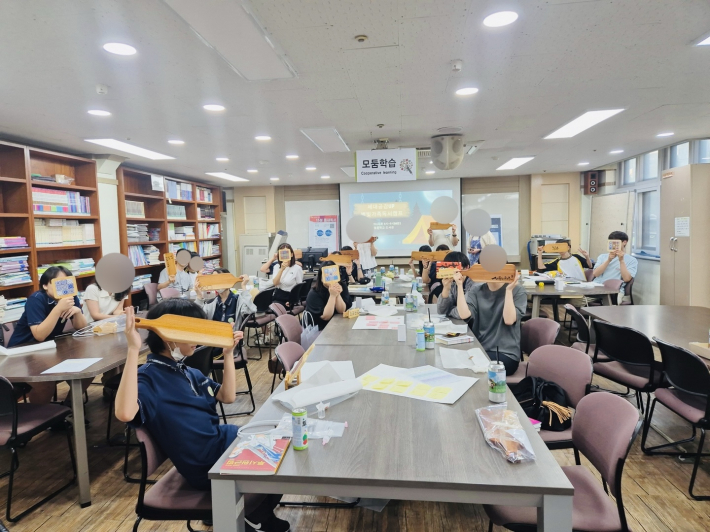 모두 자신이 만든 도마와 냄비 받침을 들어 보이며 기념촬영을 하고 있다. 