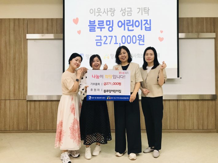 블루밍어린이집에서 사장놀이 수익금을 망포1동으로 전달하며 기념촬영을 하고 있다.