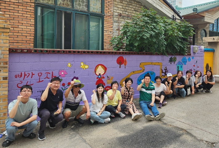 율천동 지킴이 봉사단과 관계 공무원이 벽화조성을 마치고 환하게 웃음짓고 있다.