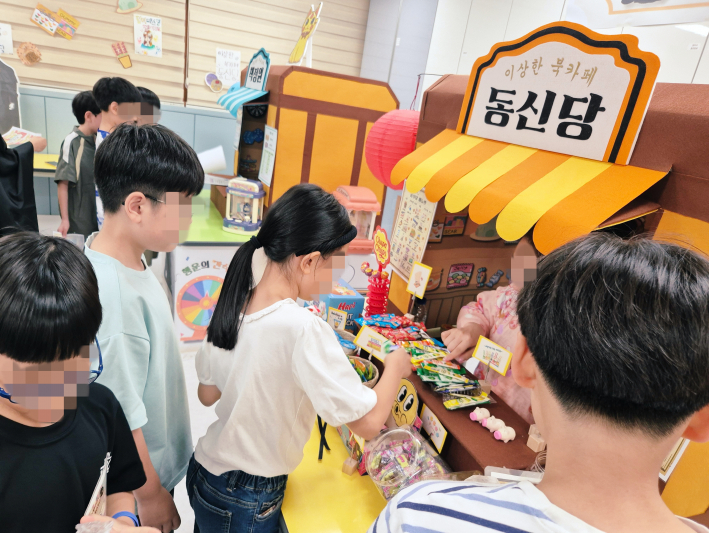 행사부스에서 동신초 학생이 간식을 고르고 있다.