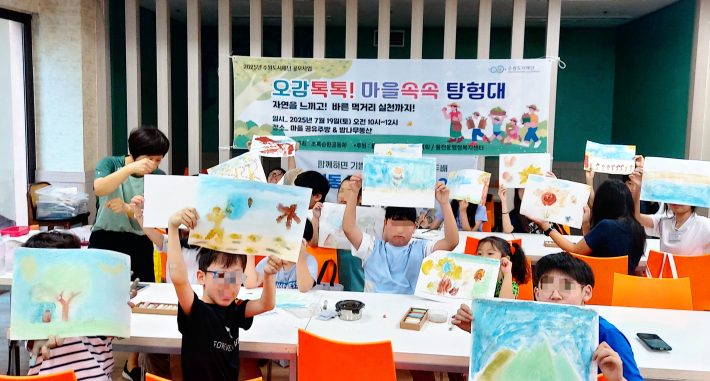 행사에 참여한 어린이들이 직접 그린 그림을 높이 들고 있다.