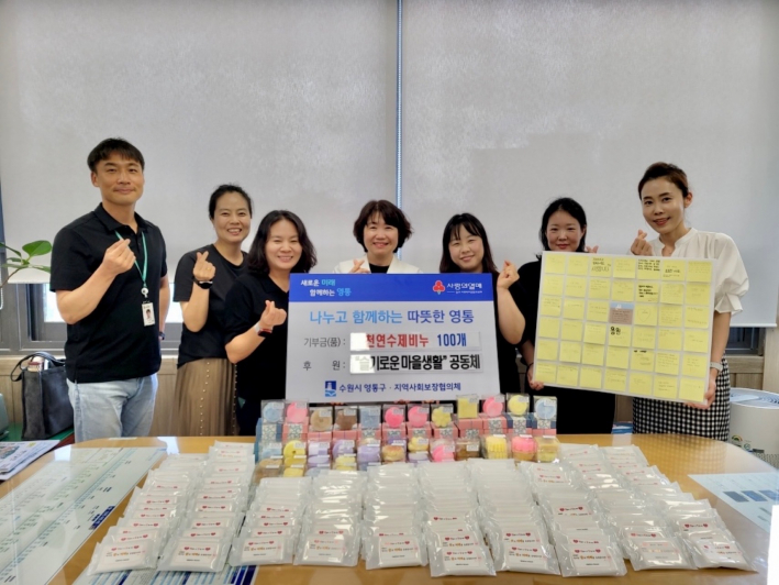  슬기로운 마을생활 공동체가 영통중학교 학생, 학부모, 교직원이 직접 만든 수제 천연비누 100개와 휴대용 물티슈 200개를 기부한 후 기념촬영을 하고 있다.