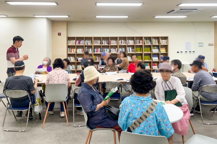 수원시 관계자가 지난 22일 어르신들을 대상으로 '똑버스' 이용법을 안내하고 있다.     