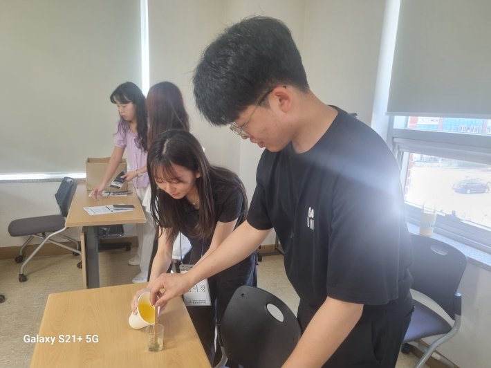 천연소이왁스 만들기 시범을 보이는 후배 시민 대학생