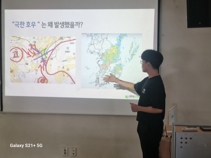 기상도를 보며 극한 호우 발생 원인을 설명하고 있다. 