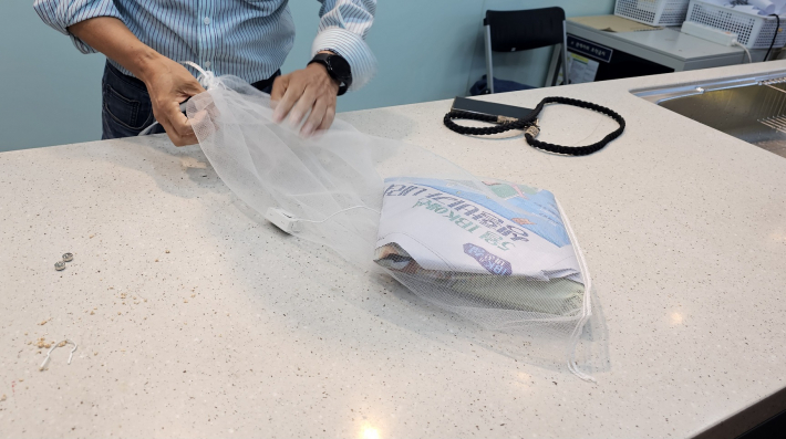 누룩재료를 종이봉투에 넣고 신문지로 싸고 망에 집어넣어 매달아 숙성시킨다