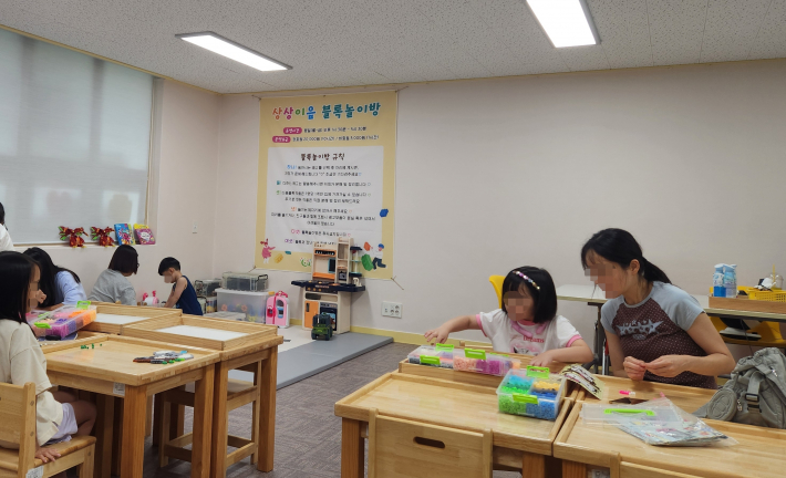 아이와 함께 블럭을 조립하고 있는 모습